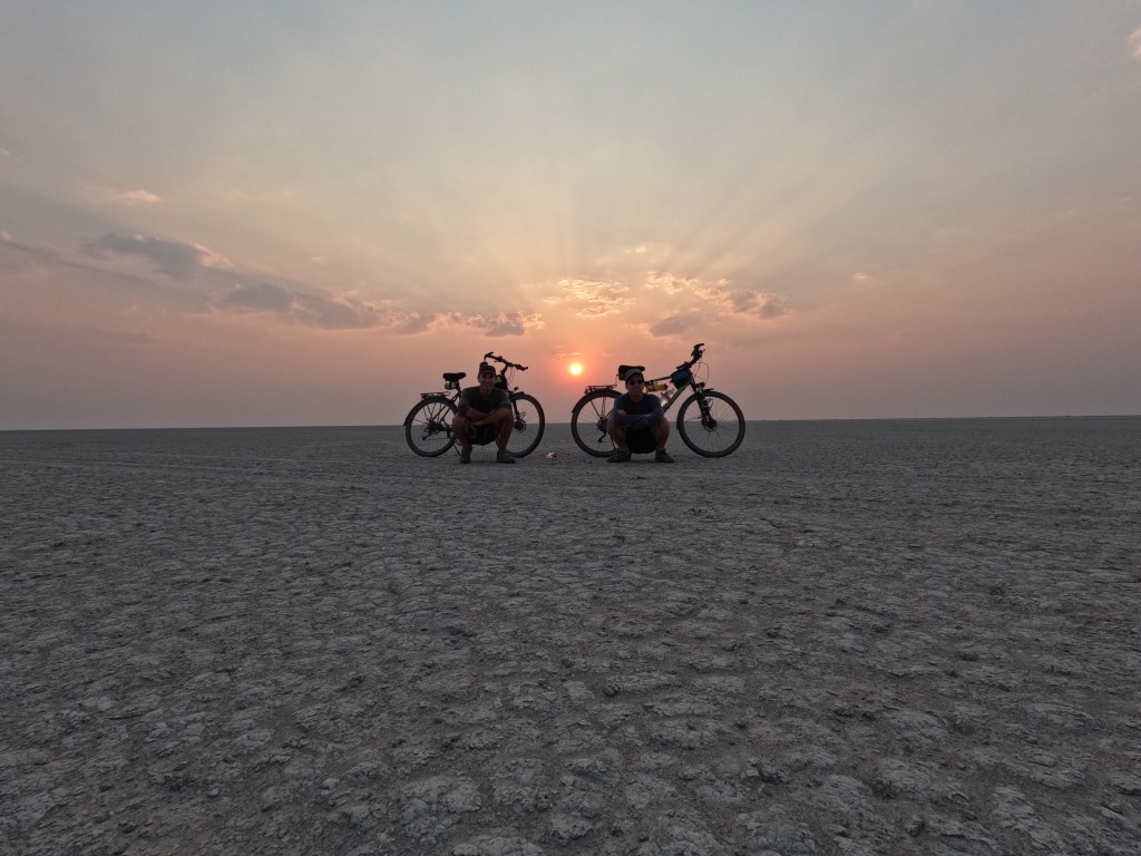 Two cyclist at sunset in Nata bird sanctuary pans 