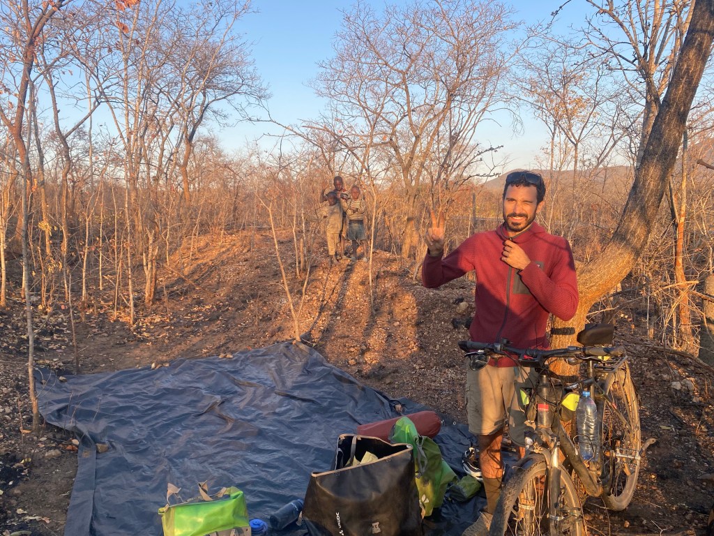 Kids watching us packing the tent in the morning while cycling to Lusaka 
