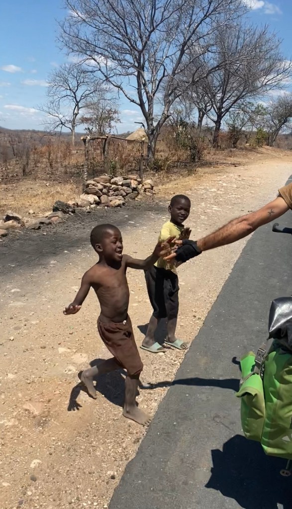 Kids welcoming us with high five while cycling 
