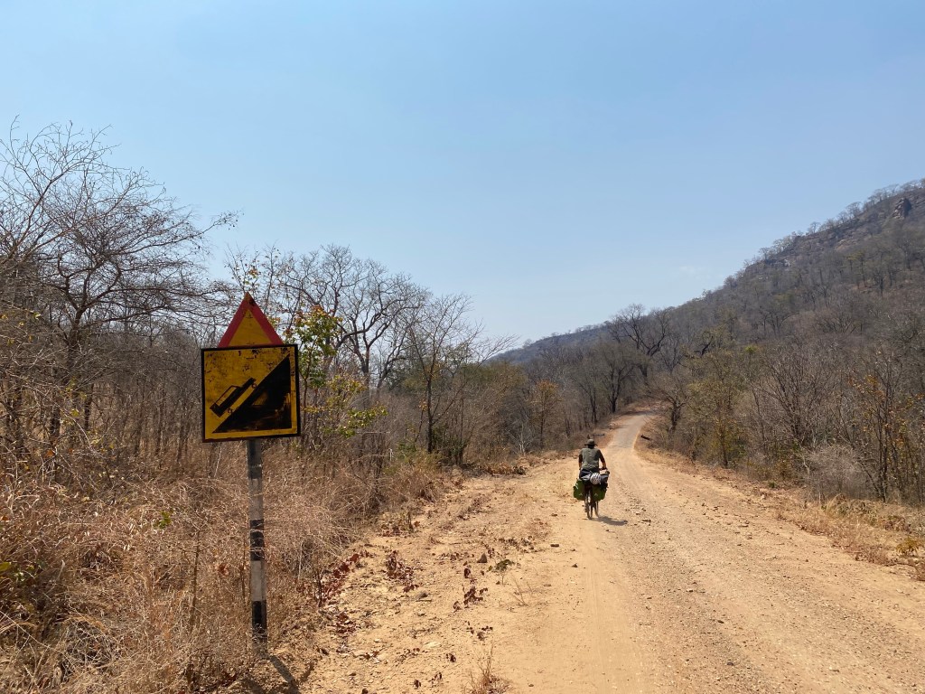 Javi climbing a hill in Zimbabwe on the bicycle