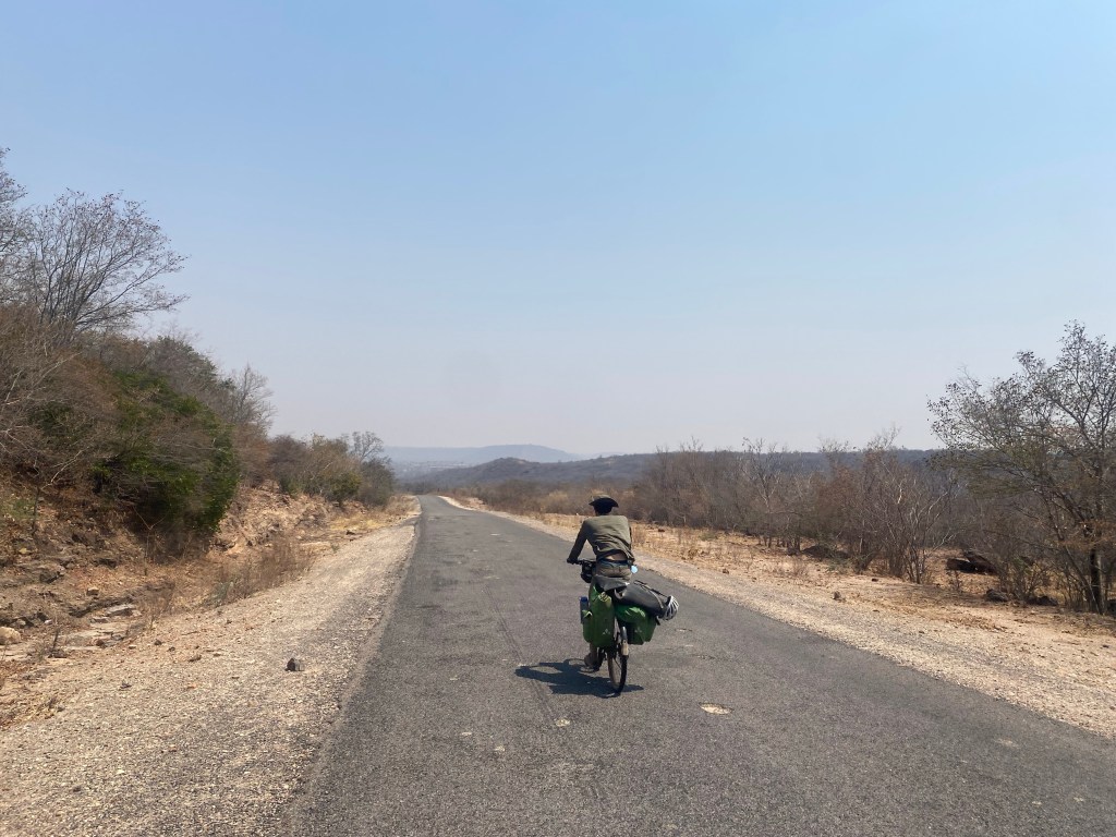 Cyclist on tarmac road in Zimbabwe