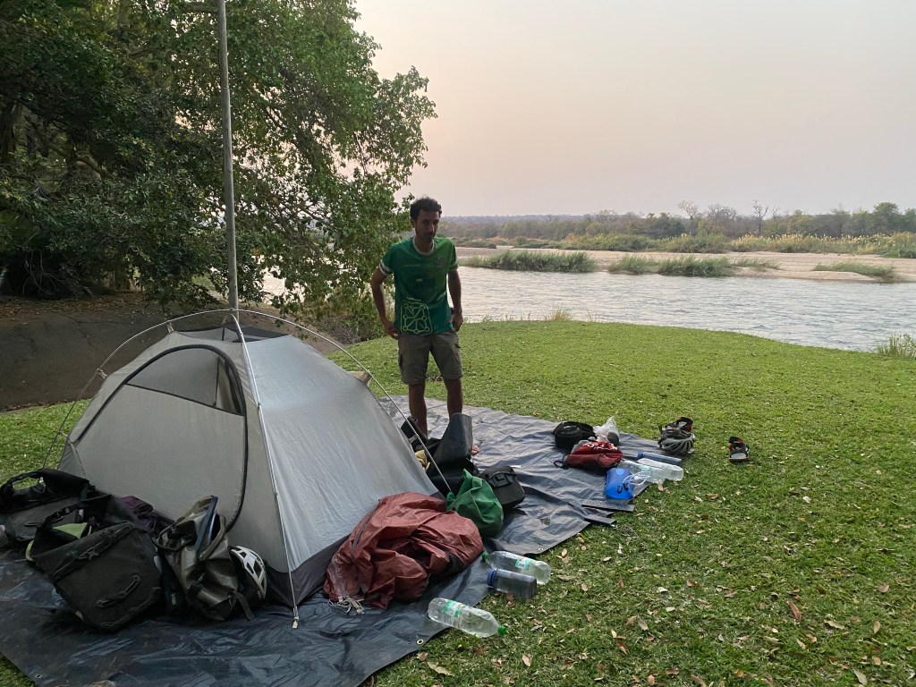 A cyclist pitching his tent by the Zambezi river in Zimbabwe