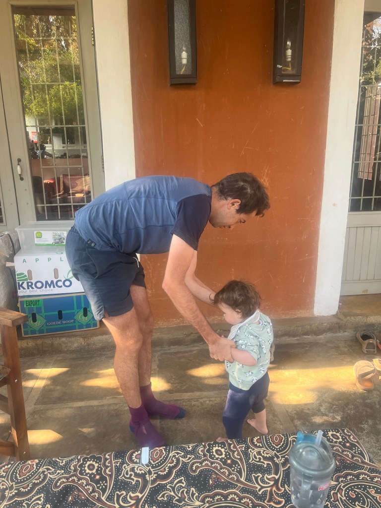 Gaspard teaching a baby how to walk during our stay in luskaa