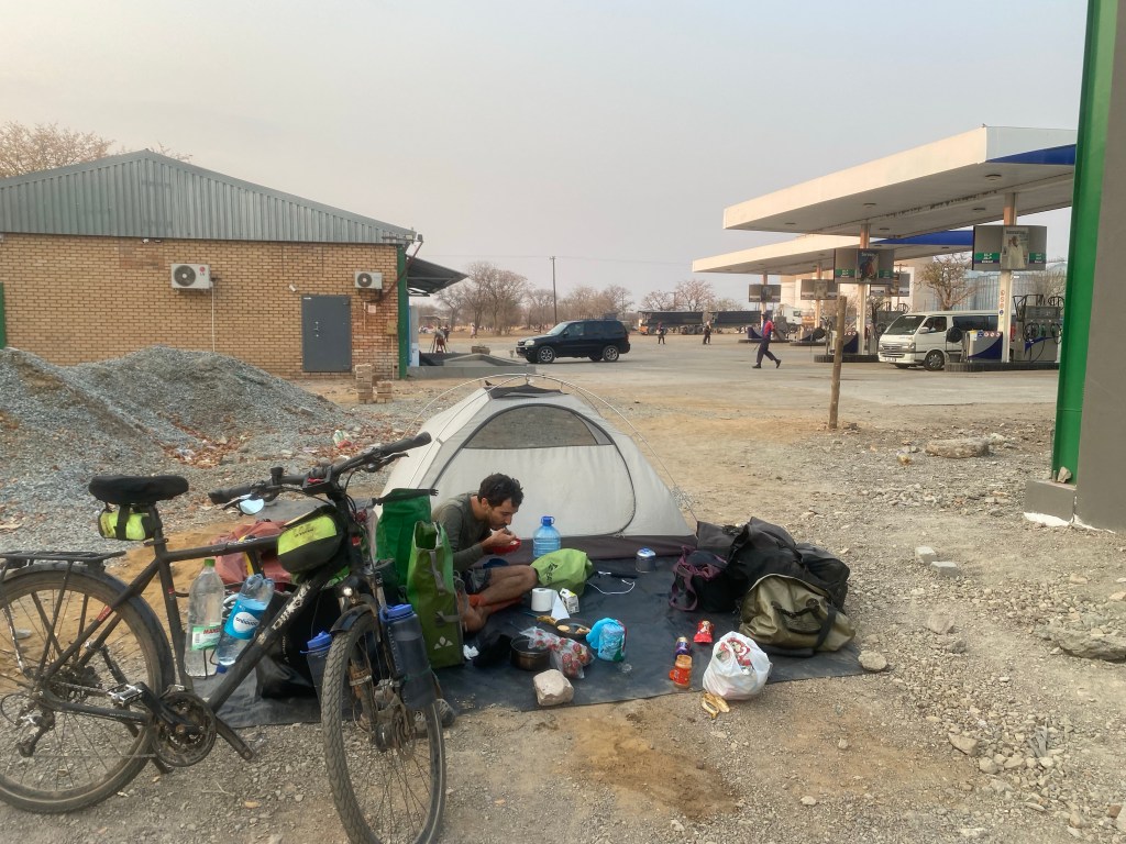 Cyclist camping by a gas station in Botswana 