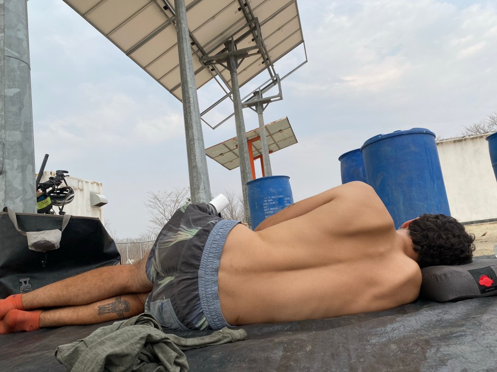 A cyclist having a nap under solar panels in Botswana 