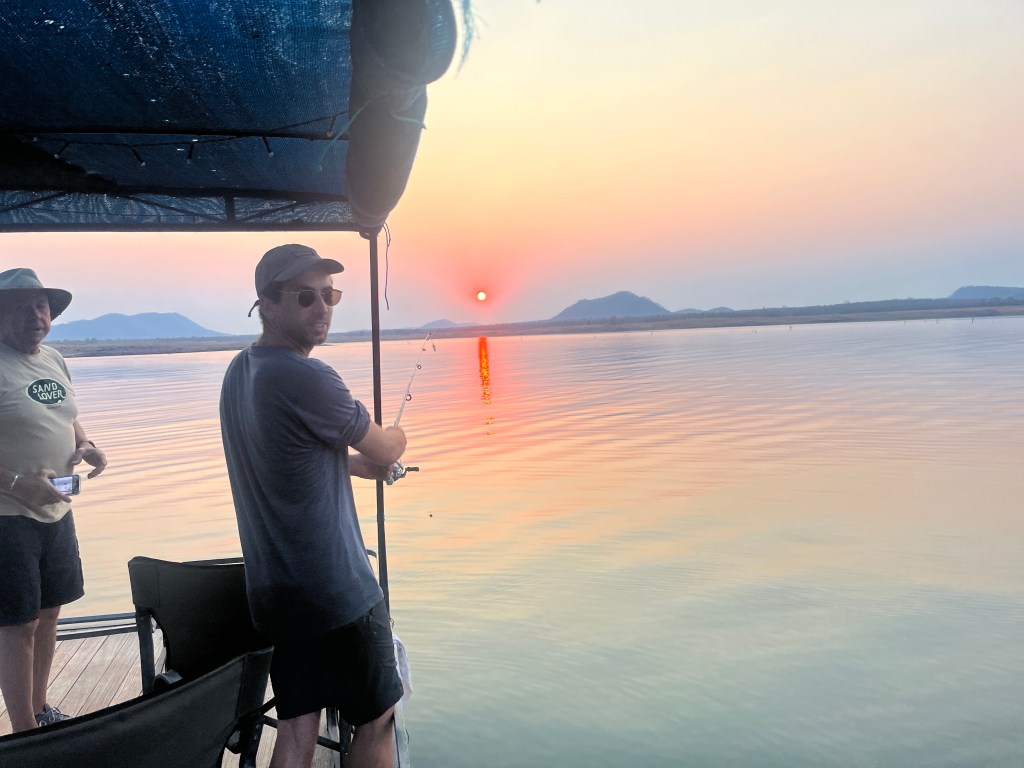 Gaspard fishing from a boat into the lake kariba