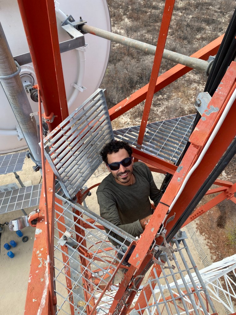 Cyclist climbing a communication antenna in Botswana 