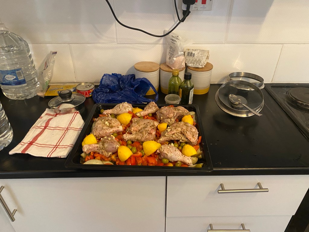 An oven tray of chicken and vegetables in an Airbnb after a day of cycling to Maun 