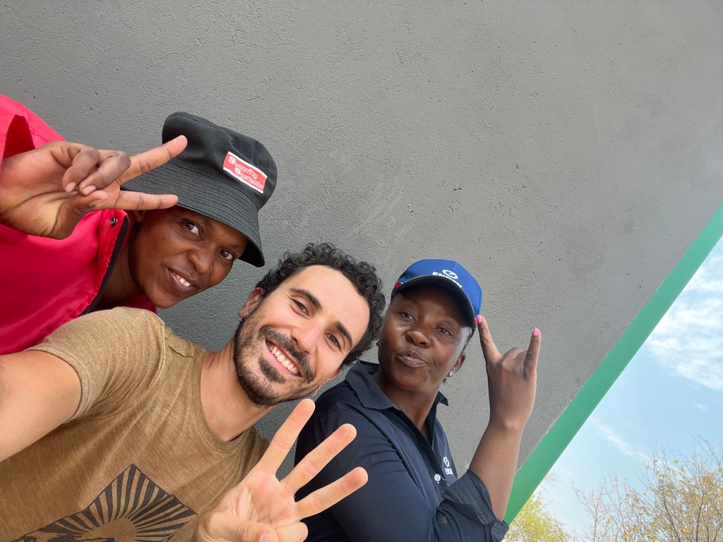 Cyclist and locals near a gas station in Botswana 