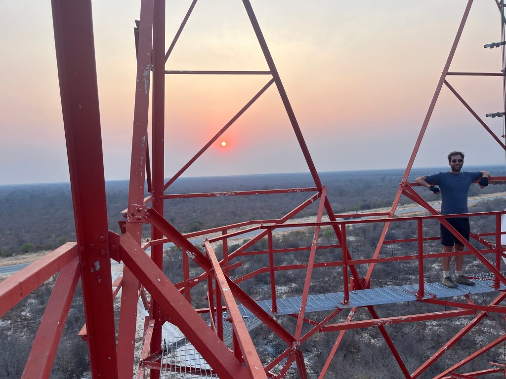 A cyclist in a commutation antenna in Botswana with the sunset in the background 