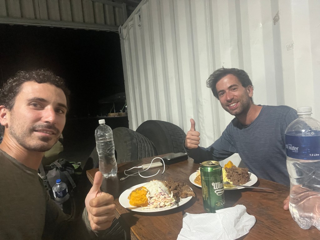 Two cyclist eating dinner in a truck filling station in Botswana border 