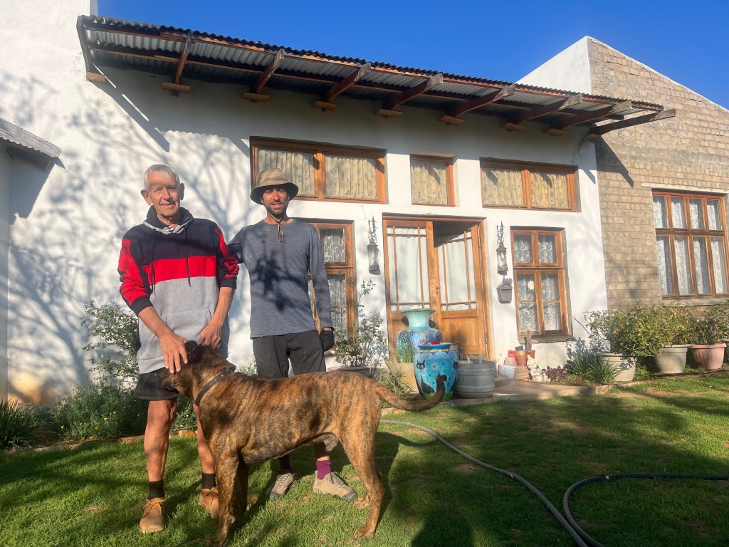 A cyclist and his host in front of his house in seeis namibia 